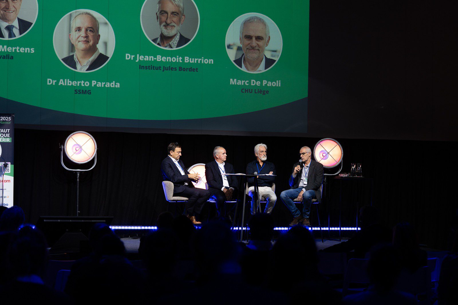 Table ronde de quatre intervenants sur la scène du Symposium 2025 Namur