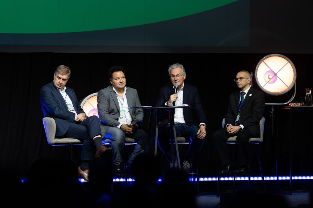 Une table ronde de quatre intervenants, l'un d'eux au micro